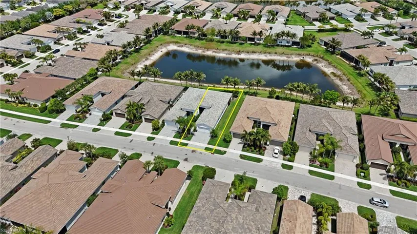 Aerial perspective showcasing a single-story residence with a tile roof and attached garage, situated on a street with sidewalks