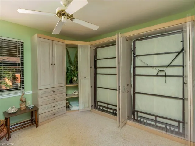 Bedroom featuring ceiling fan and two twin murphy beds.