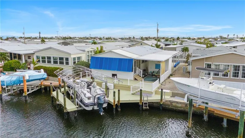 View of dock with a water view and custom awning on back of house