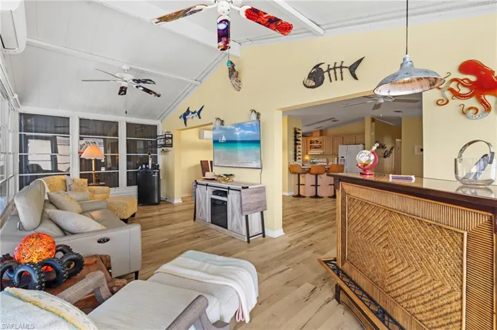 Living room with lofted ceiling and light wood-style flooring
