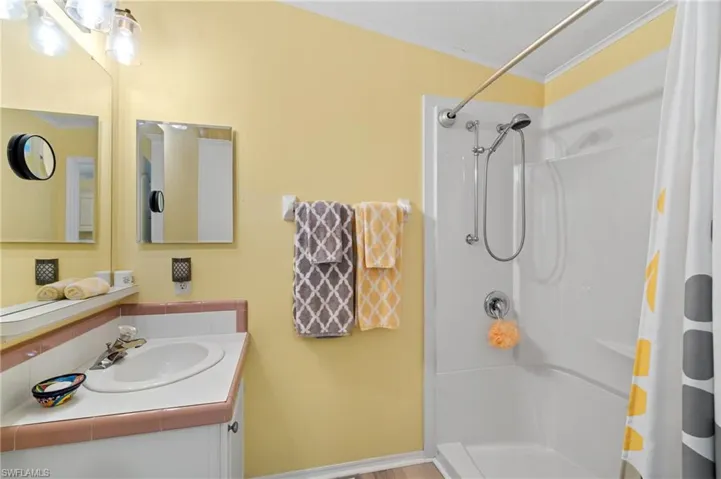 Bathroom with crown molding, vanity, and a shower with shower curtain
