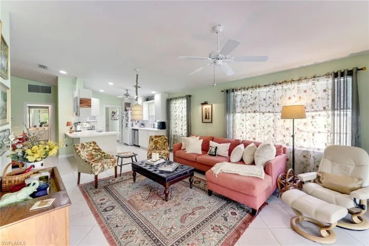 Living area with a ceiling fan, light tile patterned floors, and recessed lighting