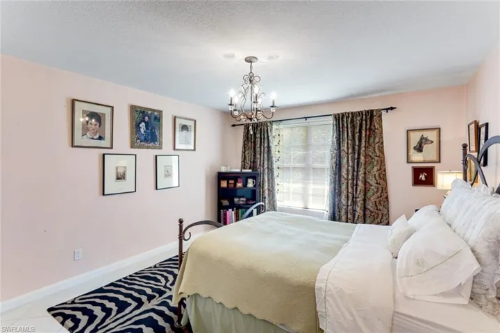 Tiled bedroom with a chandelier and a textured ceiling