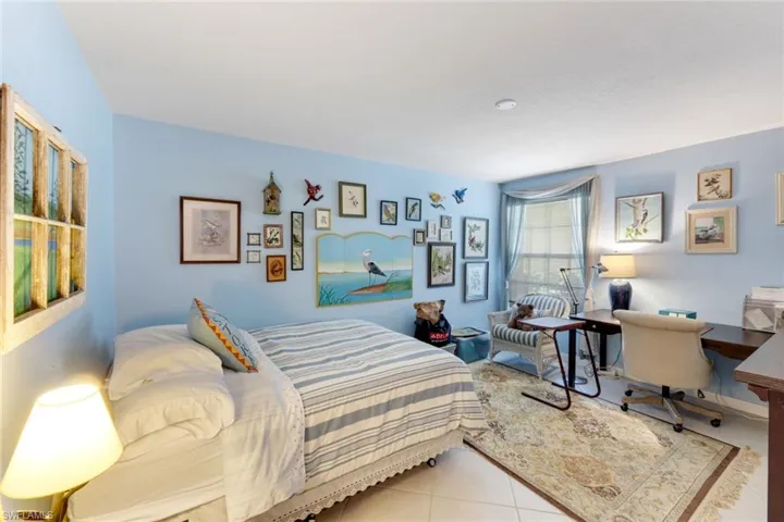 Bedroom with an office area and tile patterned floors