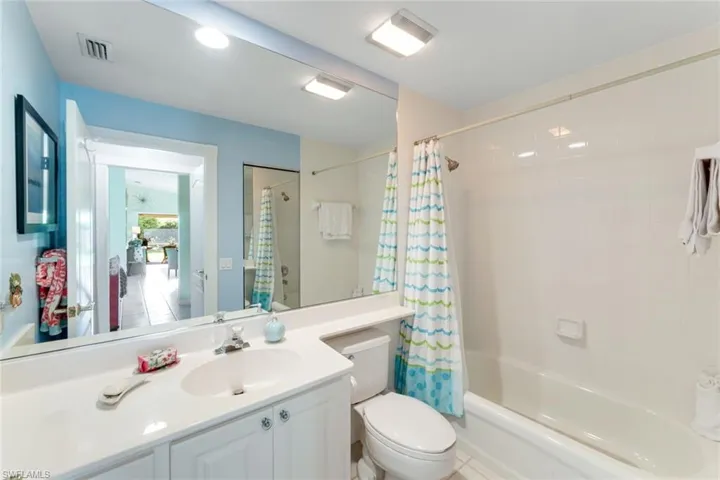 Bathroom with shower / bathtub combination with curtain and vanity