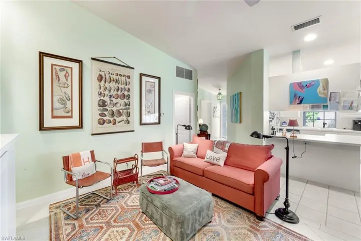 Tiled living area featuring lofted ceiling and recessed lighting