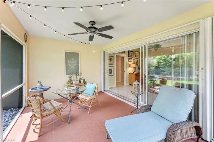 Sunroom / solarium with a ceiling fan and track lighting