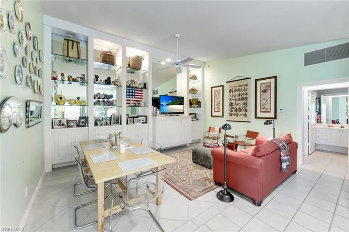 Living room featuring ceiling fan, vaulted ceiling, and light tile patterned flooring