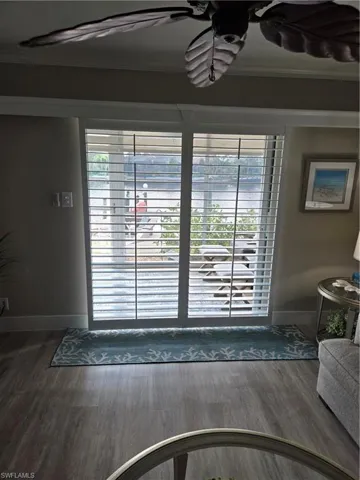 Doorway with crown molding and dark hardwood / wood-style floors