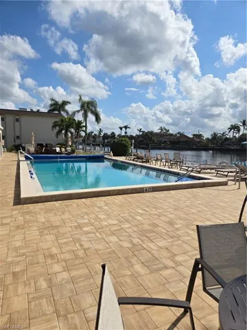 View of swimming pool featuring a patio and a water view