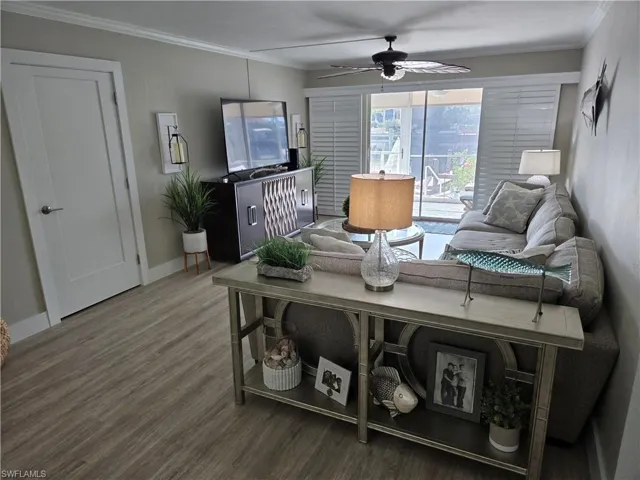 Living room featuring crown molding, hardwood / wood-style floors, and ceiling fan