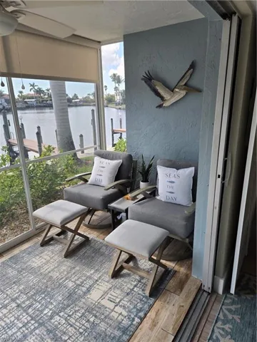 Sunroom / solarium featuring ceiling fan and a water view