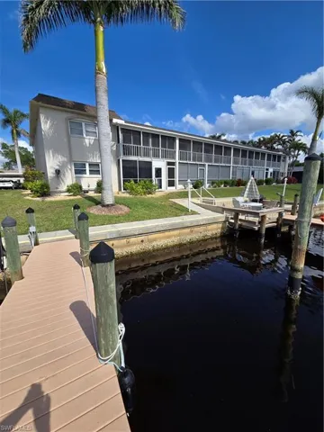 View of dock with a water view and a lawn