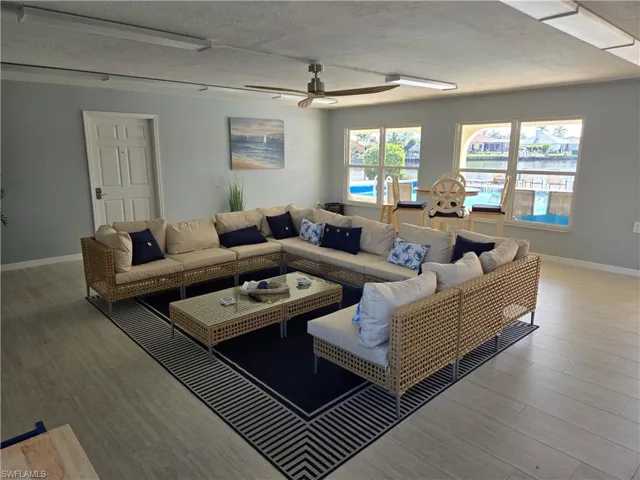 Living room featuring hardwood / wood-style flooring, ceiling fan, and a textured ceiling