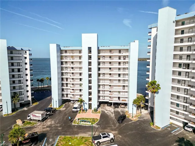 Multi-story residential buildings featuring individual balconies and a water backdrop