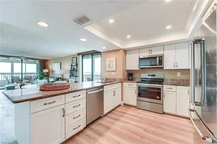 Contemporary kitchen featuring white cabinetry, stainless steel appliances, and a central island with a granite-style countertop