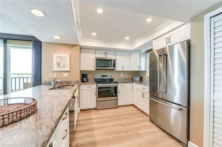 Kitchen featuring light wood-finish flooring, white cabinetry, and stainless steel appliances