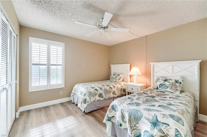 Interior room featuring wood-finish flooring, plantation shutters, and a ceiling fan