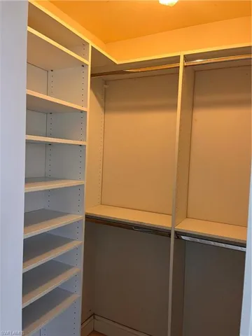 Built-in closet system featuring adjustable shelving and multiple hanging rods for organization