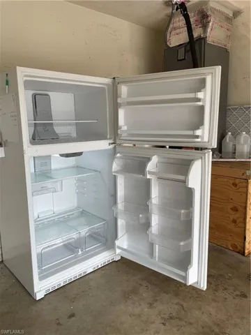 White top-freezer refrigerator featuring multiple interior shelves, transparent crisper drawers, and door storage compartments
