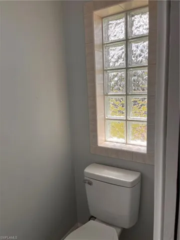 Rectangular glass block window with tiled surround and white commode