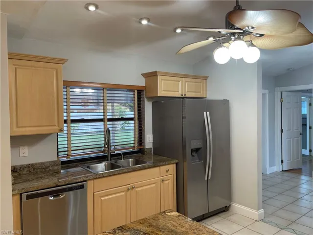 Kitchen featuring wood cabinetry, stainless steel appliances, granite countertops, and recessed lighting