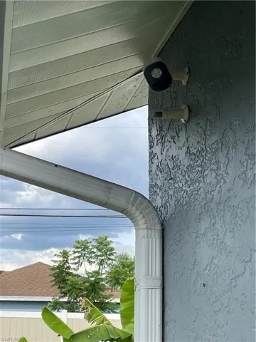 Exterior stucco wall with integrated gutter system and security camera