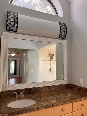 Vanity with a polished stone countertop, undermount sink, and brushed nickel faucet