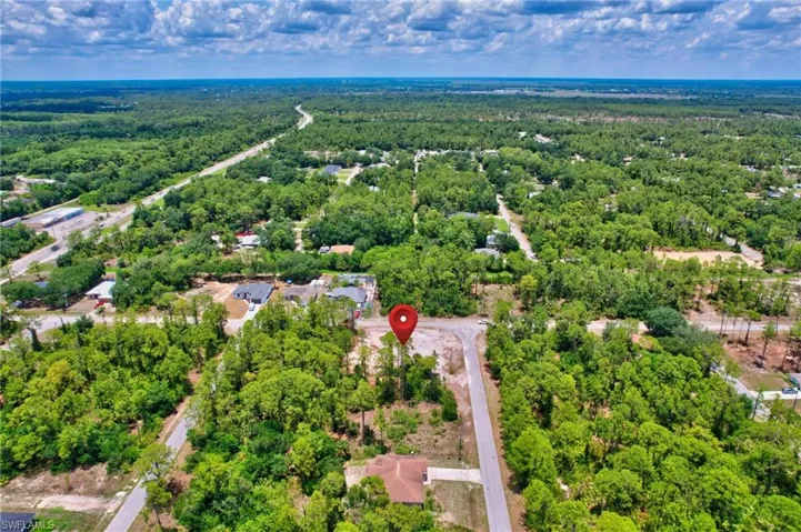 Aerial overview of property's location with a heavily wooded area