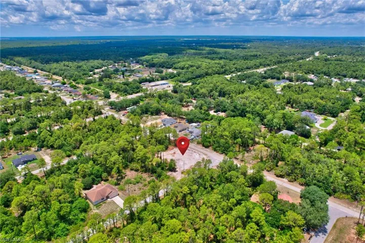 Aerial view of property's location featuring a heavily wooded area