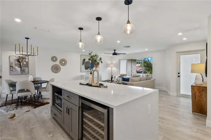 Kitchen featuring gray cabinets, decorative light fixtures, light wood-type flooring, ceiling fan, and wine cooler