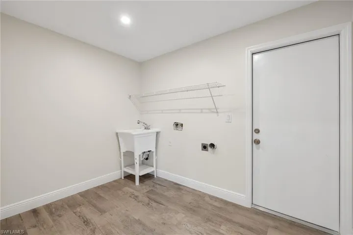 Laundry room with hookup for an electric dryer and light wood-type flooring