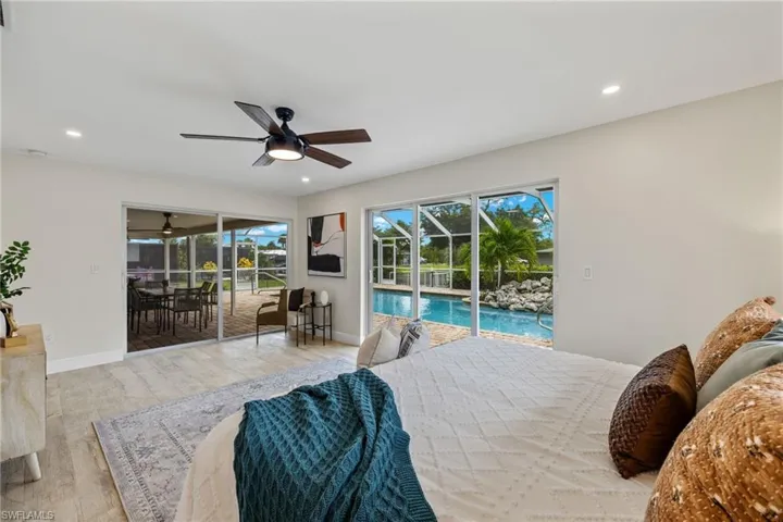 Bedroom featuring light hardwood / wood-style flooring, ceiling fan, and access to exterior