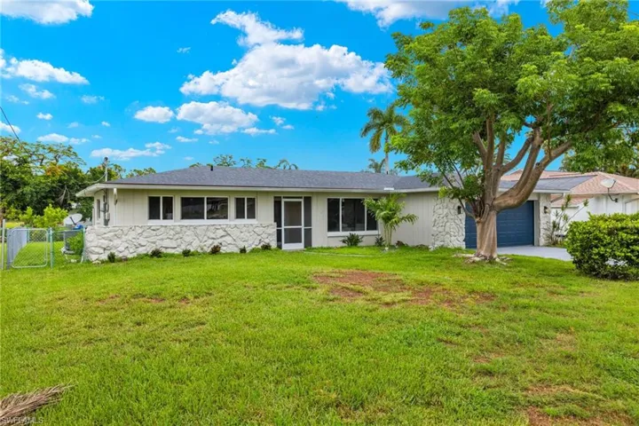 Single story home with a garage and a front yard