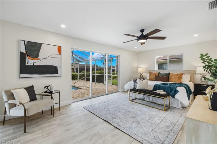 Bedroom featuring multiple windows, wood-type flooring, access to outside, and ceiling fan