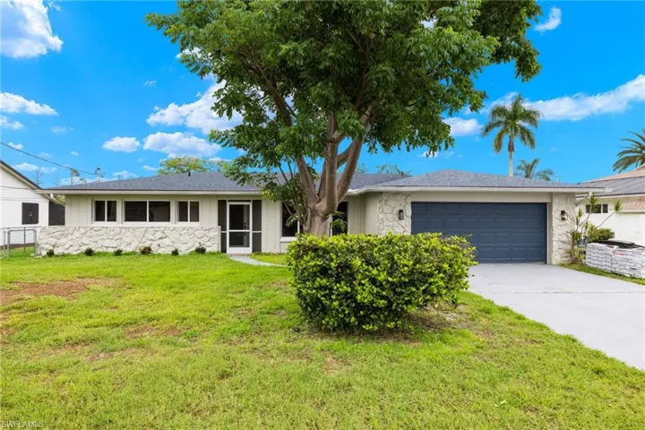 Ranch-style house with a garage and a front yard