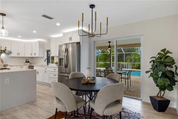 Dining area featuring an inviting chandelier, sink, and light hardwood / wood-style flooring