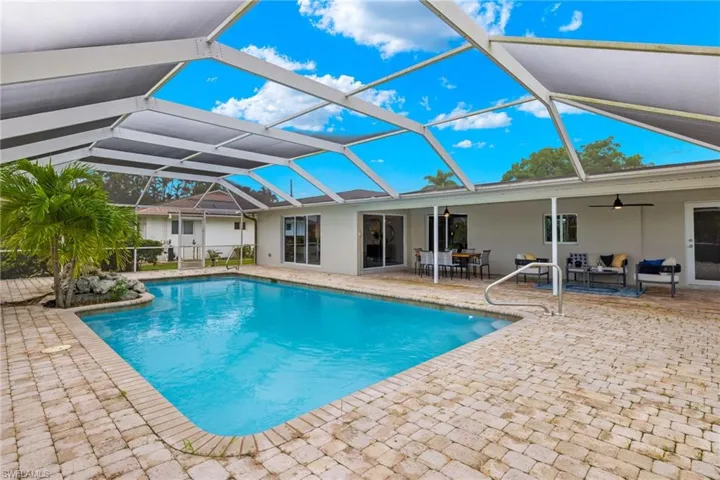 View of pool with a lanai, a patio, an outdoor living space, and ceiling fan