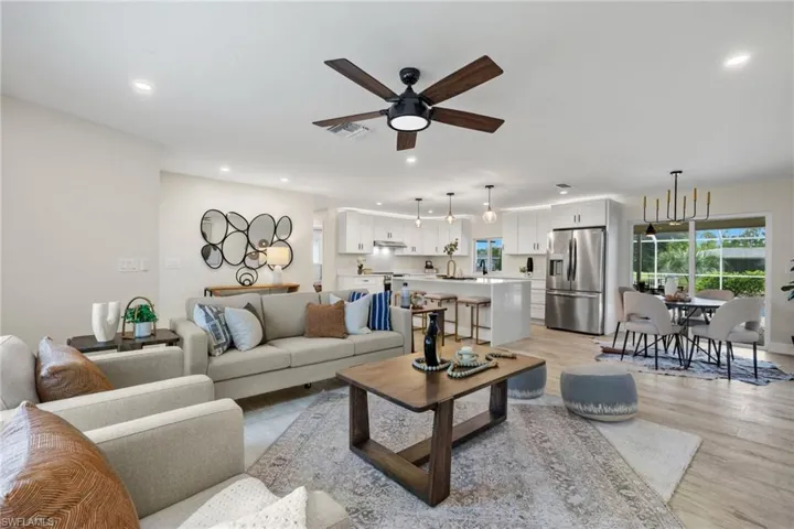 Living room with sink, light hardwood / wood-style flooring, and ceiling fan