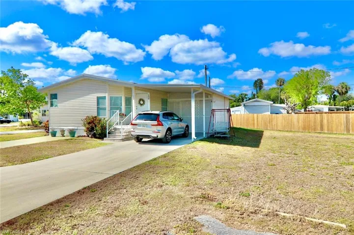 View of front of home with driveway and a carport