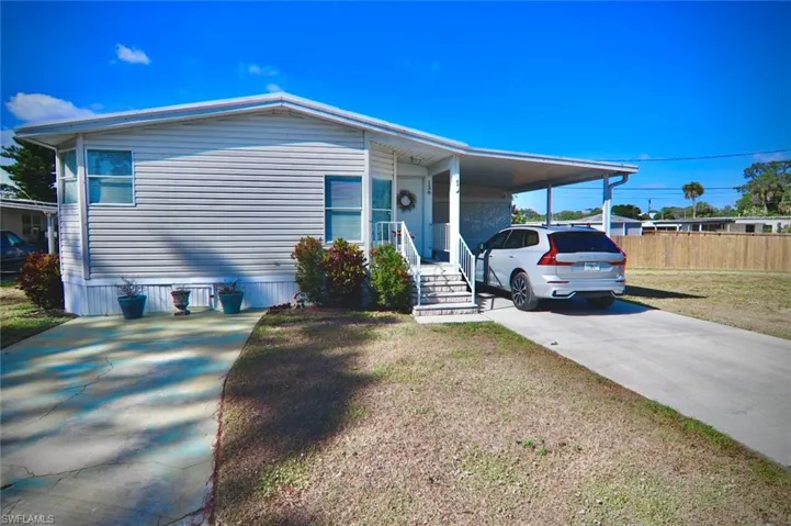 Manufactured / mobile home featuring driveway and an attached carport