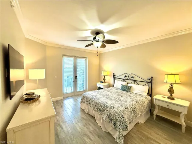 Bedroom with ornamental molding, access to exterior, light wood-style floors, a ceiling fan, and french doors