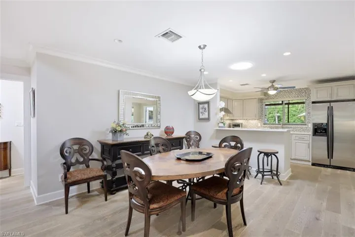 Dining room featuring light wood-style flooring, crown molding, a ceiling fan, recessed lighting, and baseboards