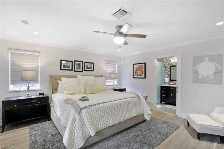 Bedroom featuring ornamental molding, light wood-style floors, ceiling fan, connected bathroom, and recessed lighting