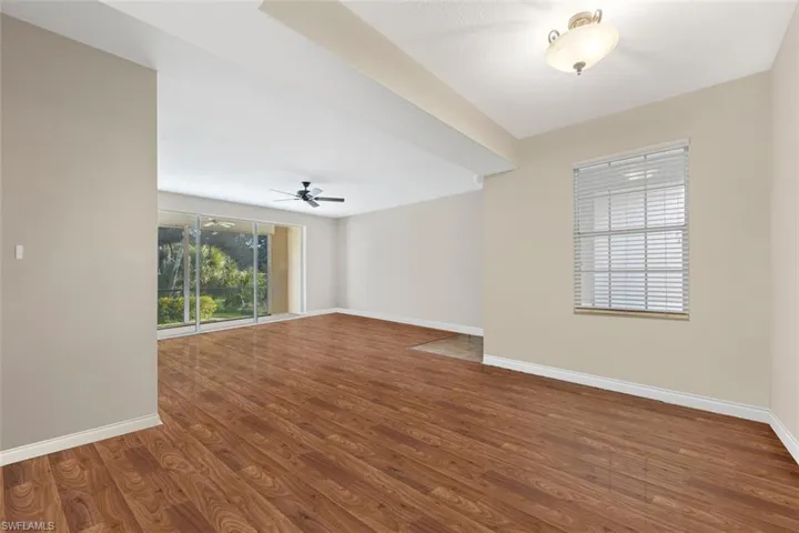 Empty room featuring wood finished floors, baseboards, and ceiling fan