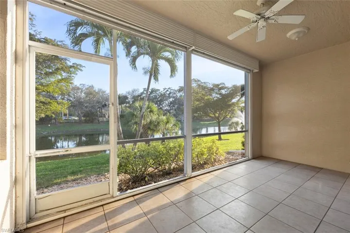 Unfurnished sunroom with a water view and ceiling fan