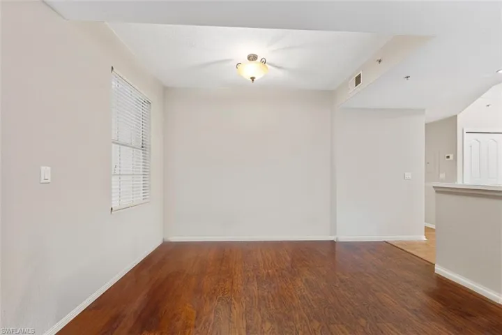 Spare room featuring visible vents, baseboards, and wood finished floors