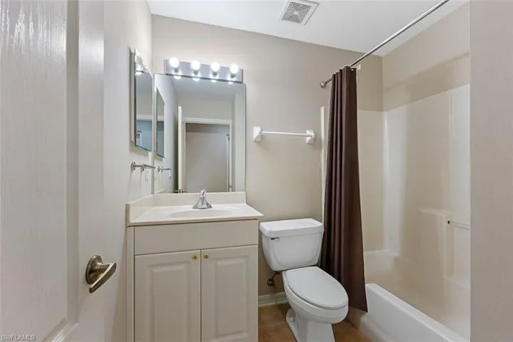 Full bathroom with vanity, toilet, and visible vents