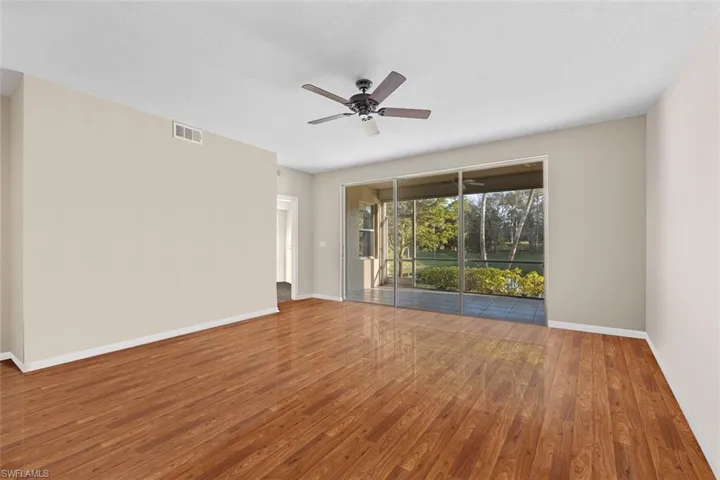 Spare room featuring baseboards, visible vents, and wood finished floors