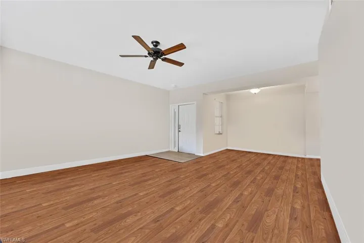 Spare room with ceiling fan, wood finished floors, and baseboards